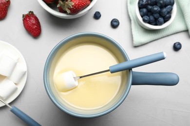 Photo of Flat lay composition with white chocolate fondue on light background