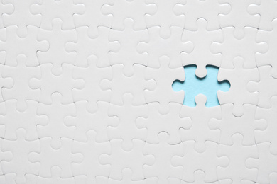 Photo of Blank white puzzle with missing piece on light blue background, top view. Space for text