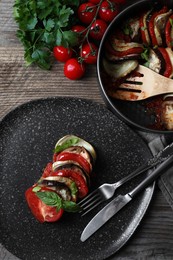 Photo of Delicious ratatouille served with basil on wooden table, flat lay