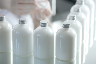 Photo of Many bottles with cosmetic product in laboratory