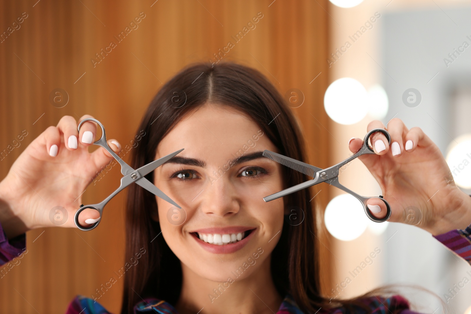 Photo of Hairstylist holding professional scissors in beauty salon