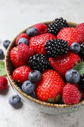 Photo of Different fresh ripe berries on light grey table, closeup
