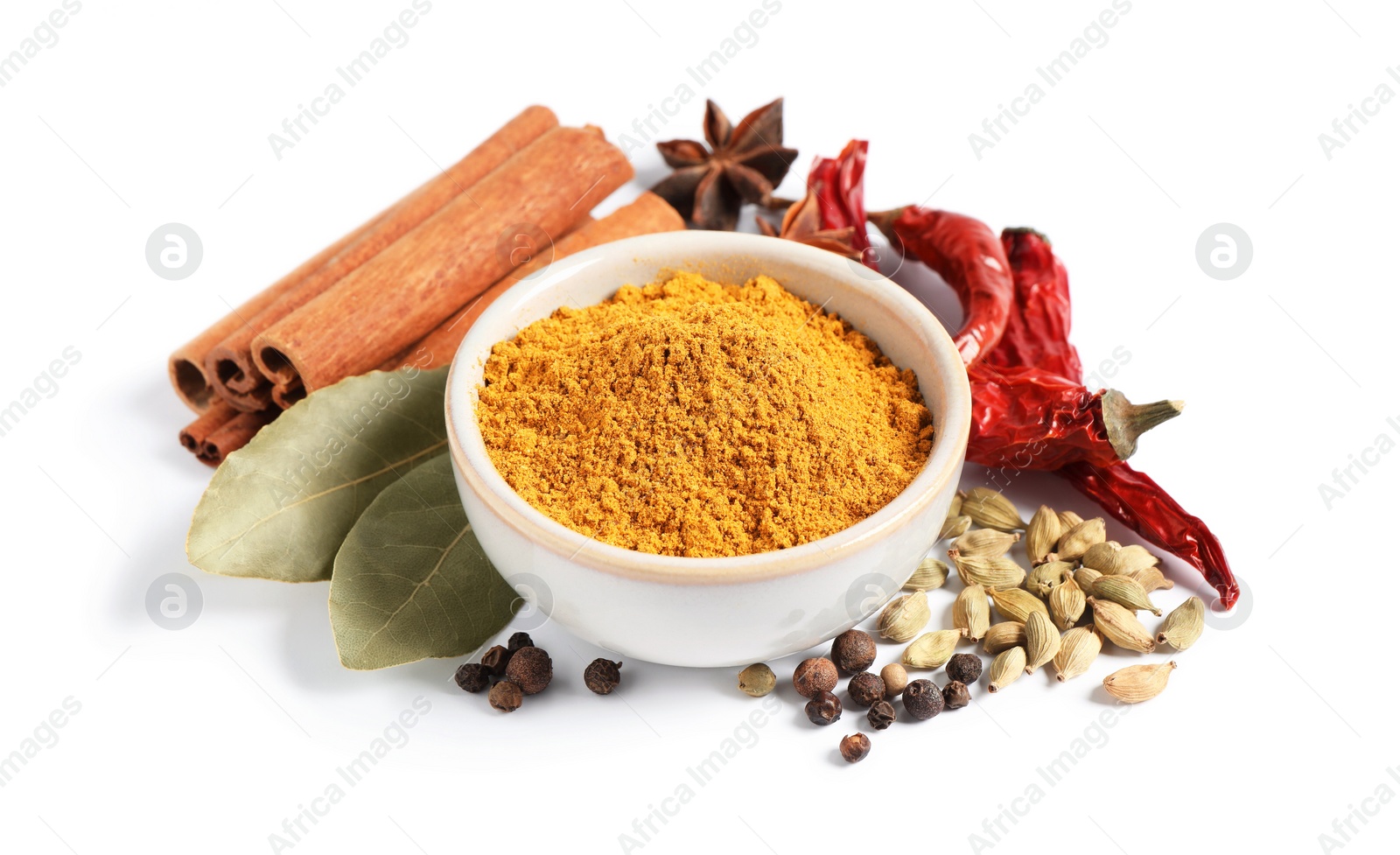 Photo of Curry powder in bowl and other spices isolated on white