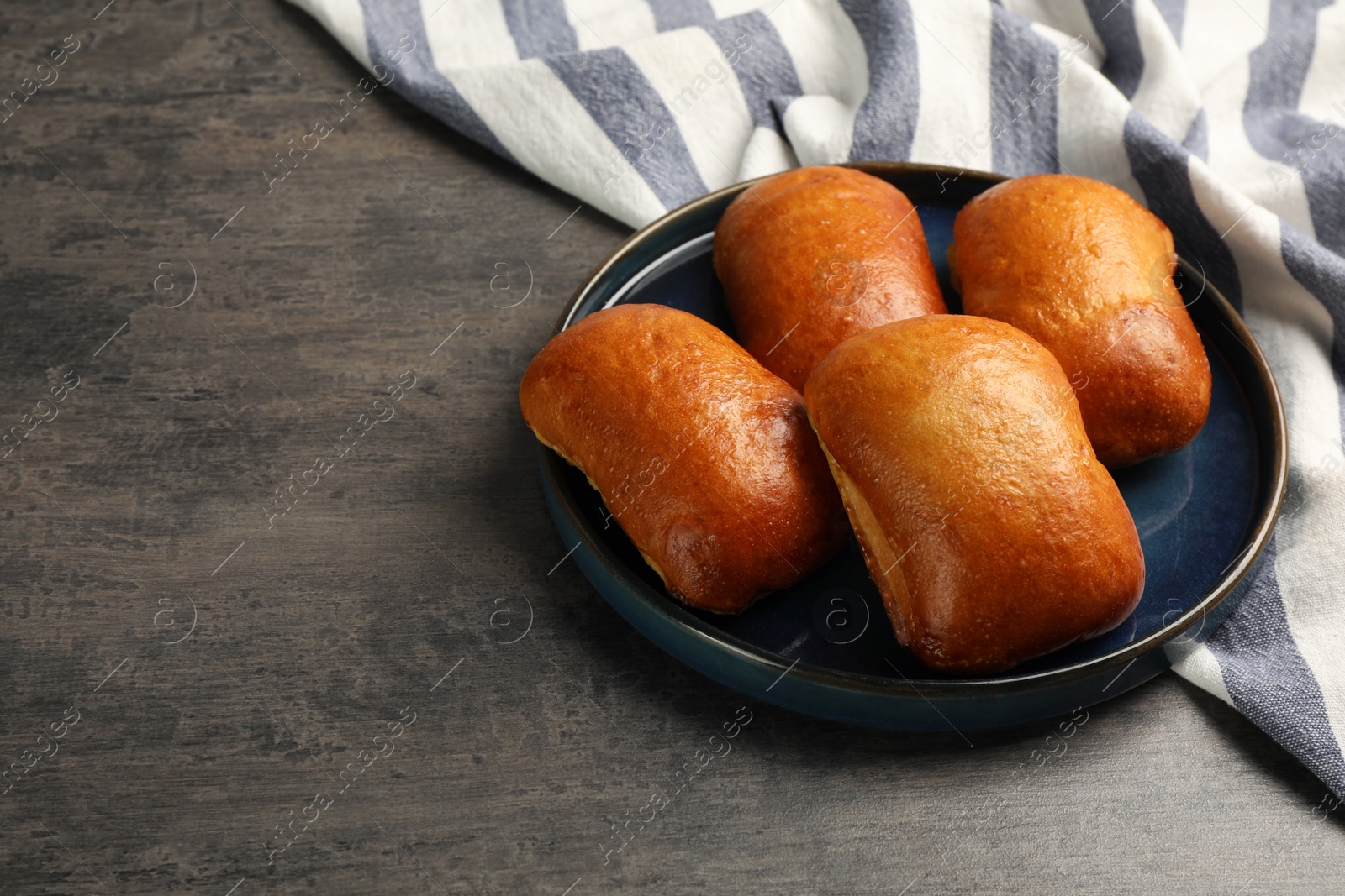 Photo of Delicious baked patties on grey table, space for text