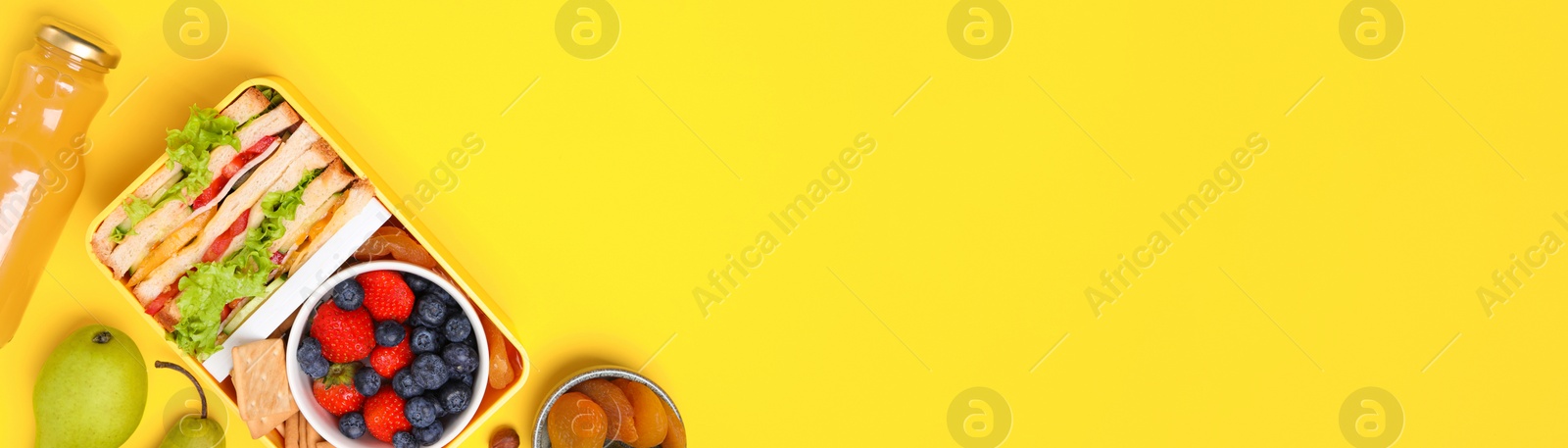 Image of School meal. Flat lay composition with lunch box, tasty healthy food and juice on yellow background, space for text. Banner design