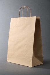 Photo of One kraft paper bag on grey background. Mockup for design