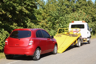 Photo of Broken car and tow truck on country road