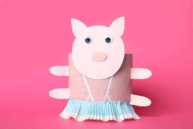 Photo of Toy pig made of toilet paper roll on pink background
