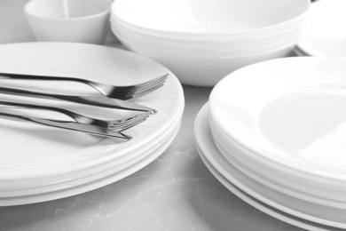 Photo of Many stacked plates with cutlery, closeup