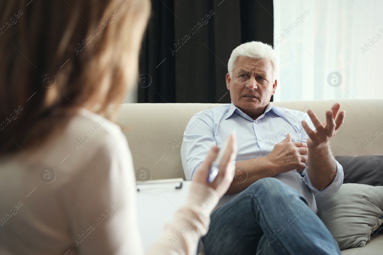 Photo of Professional psychotherapist working with patient in office