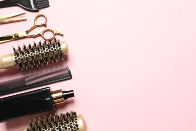 Photo of Professional hair dresser tools on pink background, flat lay. Space for text