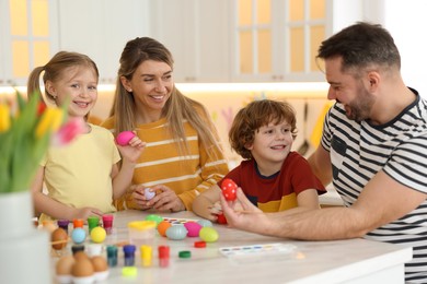 Photo of Happy Easter. Cute family with painted eggs at white marble table in kitchen