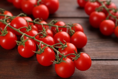 Fresh ripe cherry tomatoes on wooden table, closeup