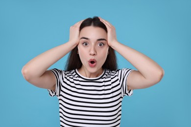 Photo of Portrait of surprised woman on light blue background