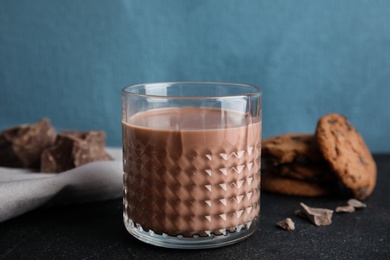 Photo of Glass of tasty chocolate milk on dark table. Dairy drink