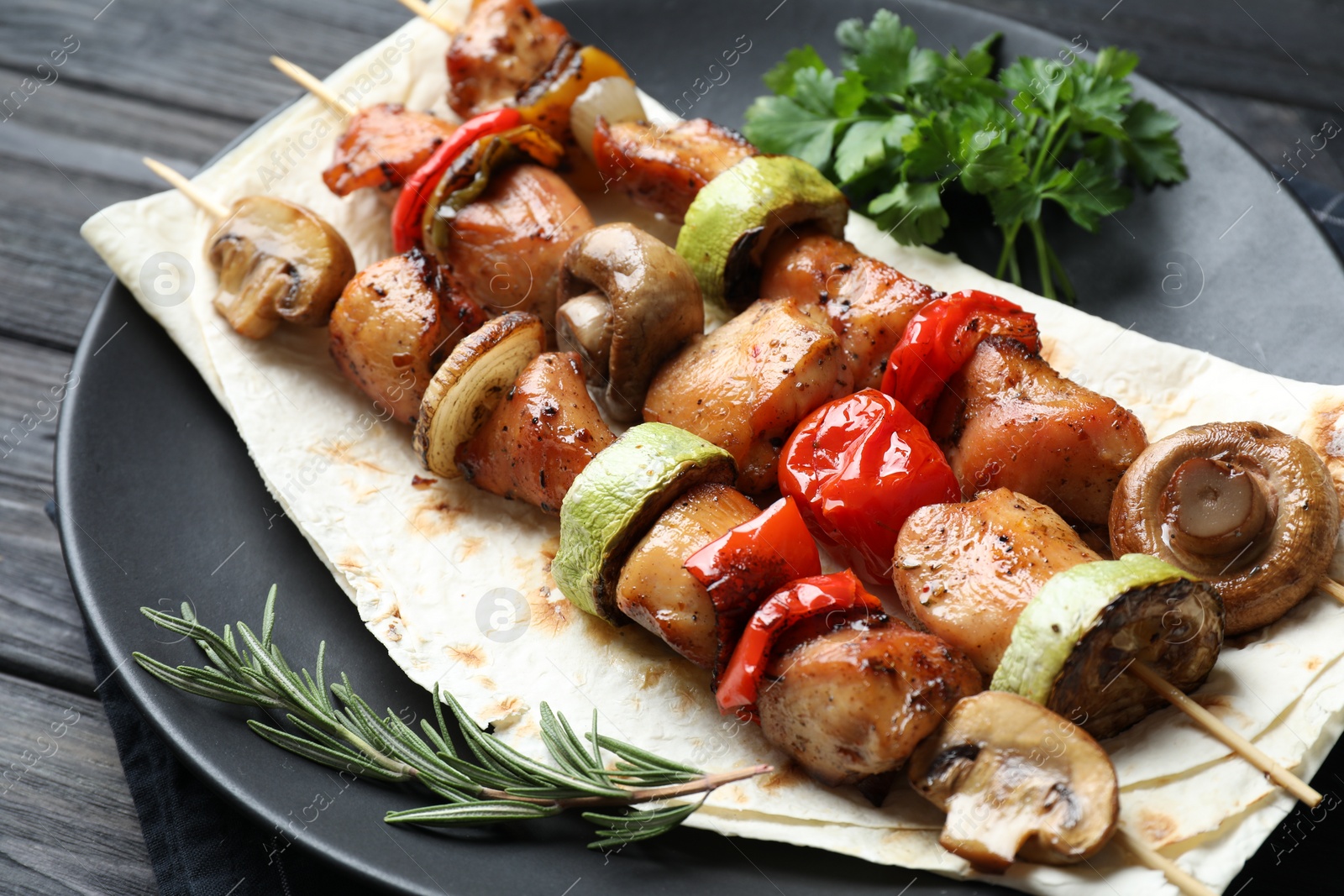 Photo of Delicious shish kebabs with vegetables and spices on table, closeup