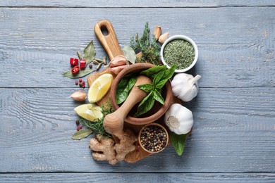 Photo of Different natural spices and herbs on grey wooden table, flat lay