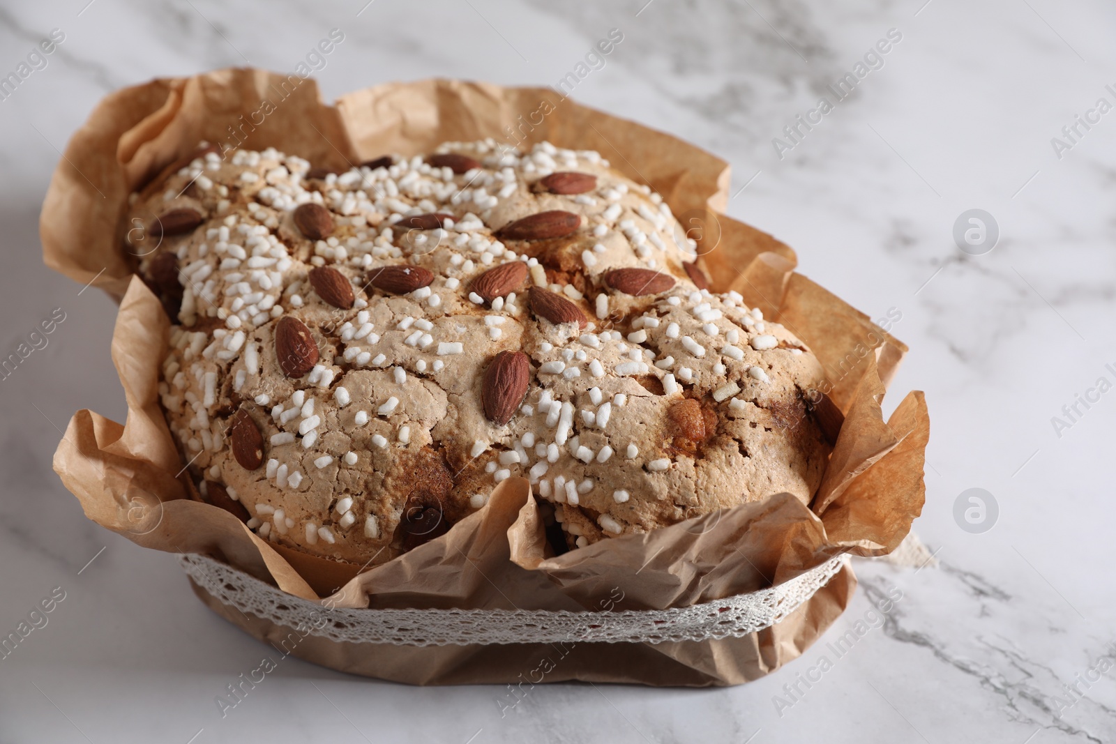 Photo of Delicious Italian Easter dove cake (Colomba di Pasqua) on white marble table, closeup