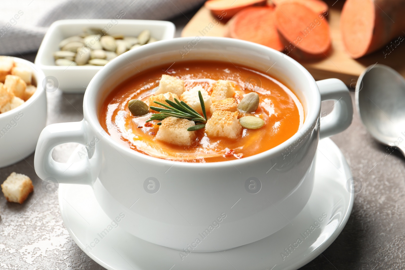 Photo of Bowl of tasty sweet potato soup served on table