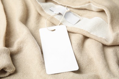 Photo of Warm beige cashmere sweater with tag, closeup
