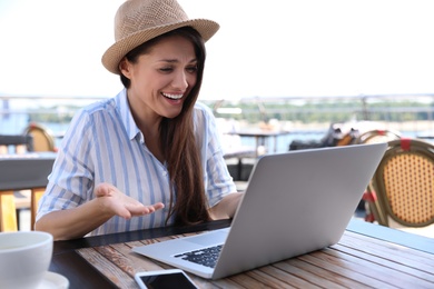Beautiful woman using laptop at outdoor cafe