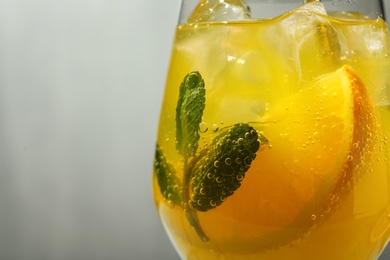 Delicious orange soda water on grey background, closeup