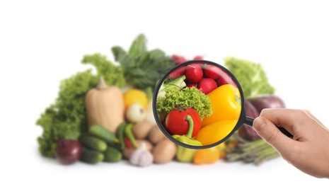 Image of Woman with magnifying glass exploring vegetables, closeup. Poison detection