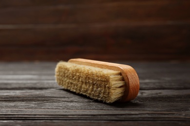 Photo of Shoe brush on wooden table. Footwear care item