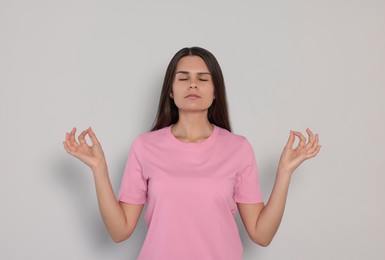 Photo of Young woman meditating on white background. Zen concept