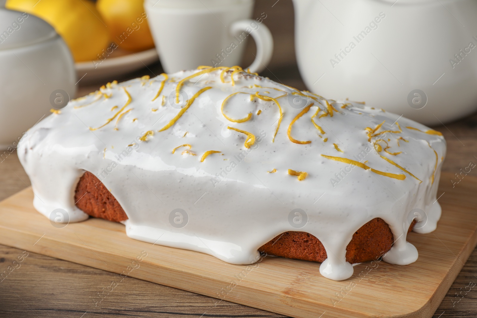 Photo of Tasty lemon cake with glaze on wooden table, closeup