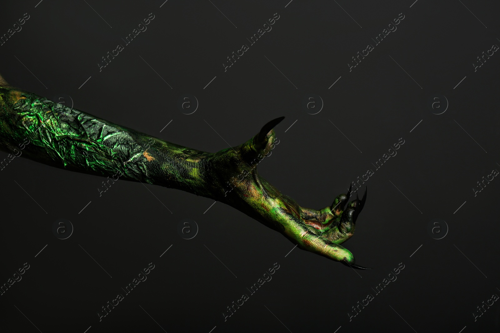 Photo of Scary monster on black background, closeup of hand. Halloween character