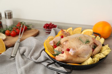 Photo of Chicken with orange and potato slices in baking pan on wooden table
