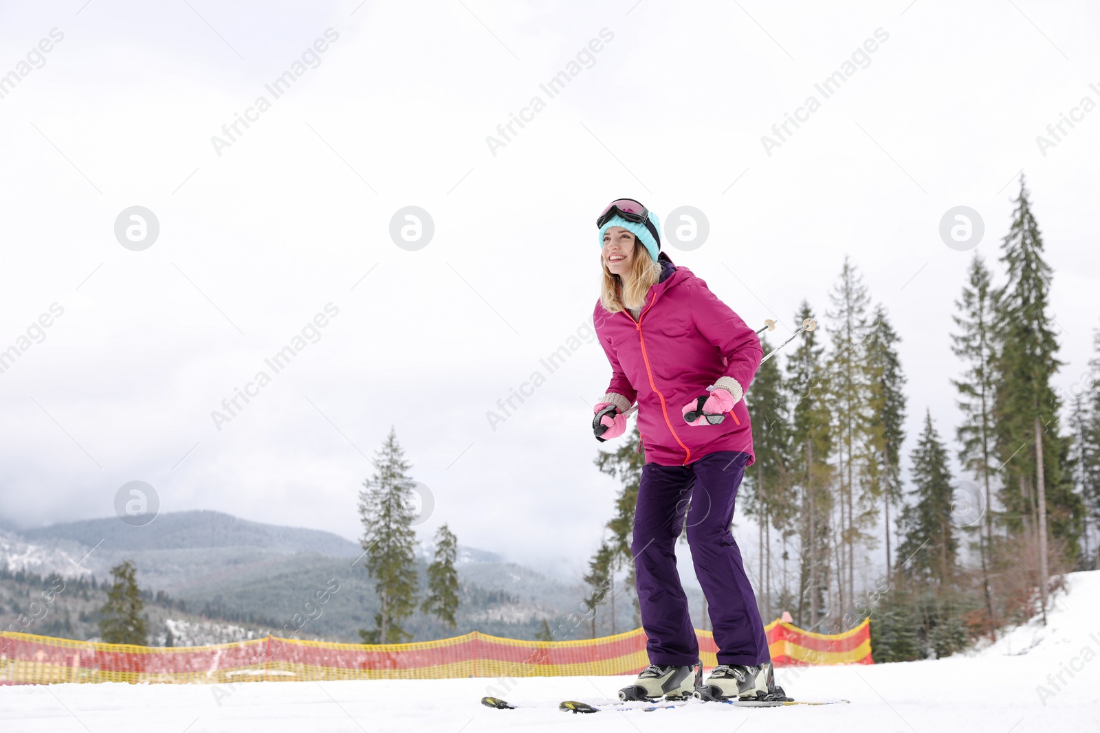 Photo of Female skier on slope at resort, space for text. Winter vacation