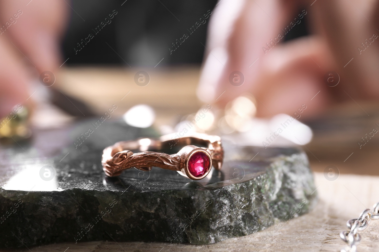 Photo of Ruby ring and blurred jeweler on background