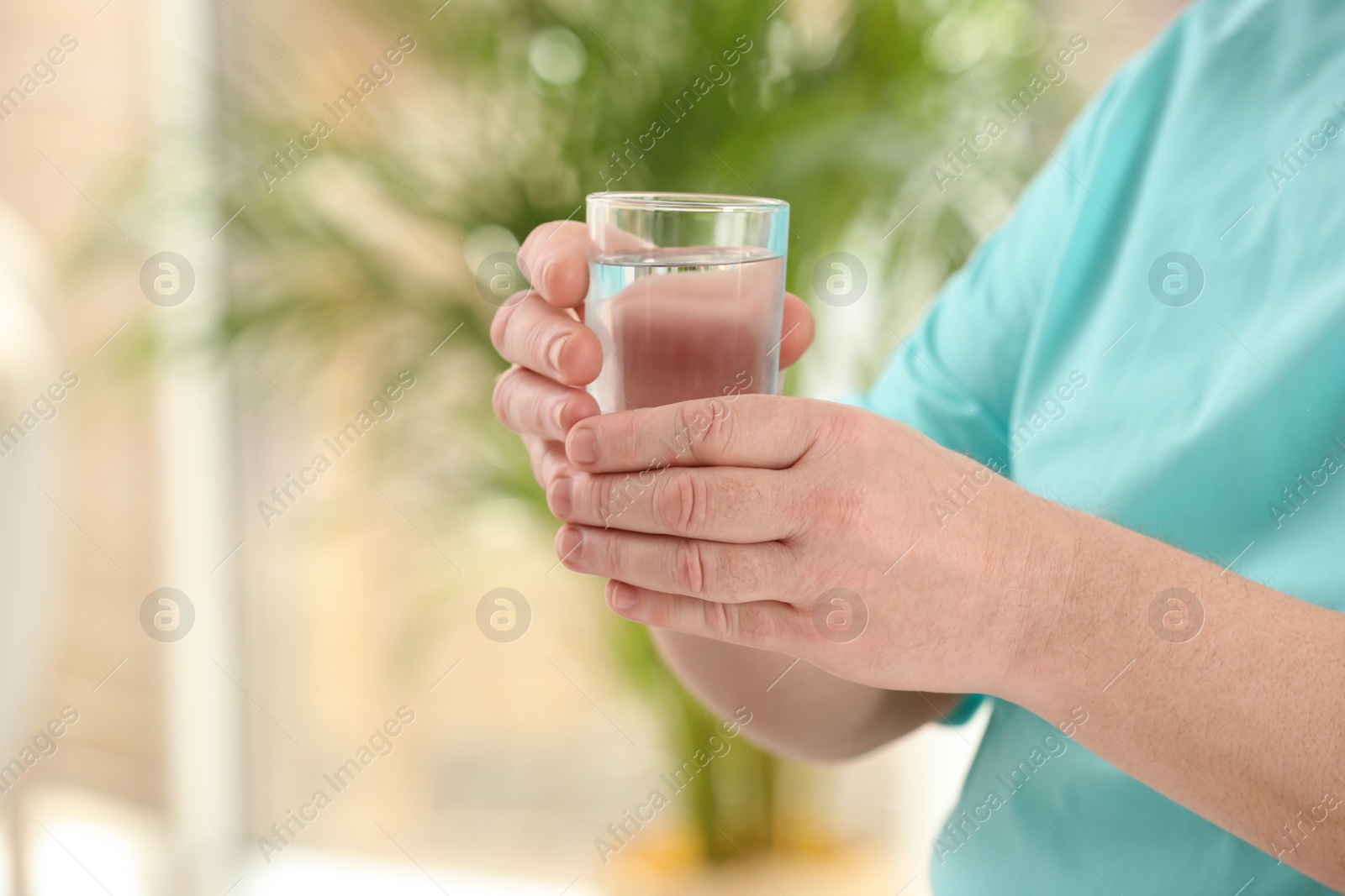 Photo of Closeup view of elderly man with glass of water in nursing home, space for text. Assisting senior generation