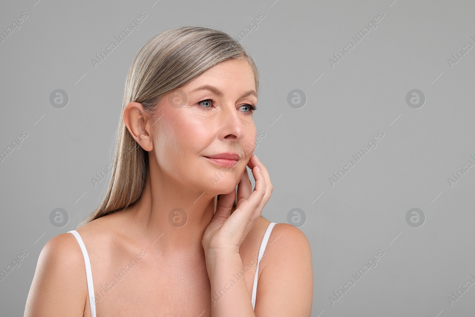 Photo of Beautiful mature woman with healthy skin on gray background, space for text