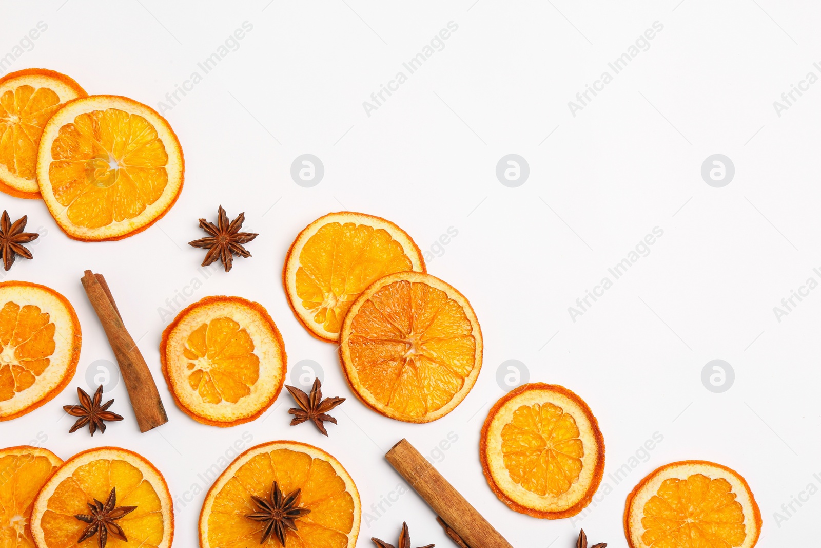 Photo of Flat lay composition with dry orange slices, anise stars and cinnamon sticks on white background. Space for text