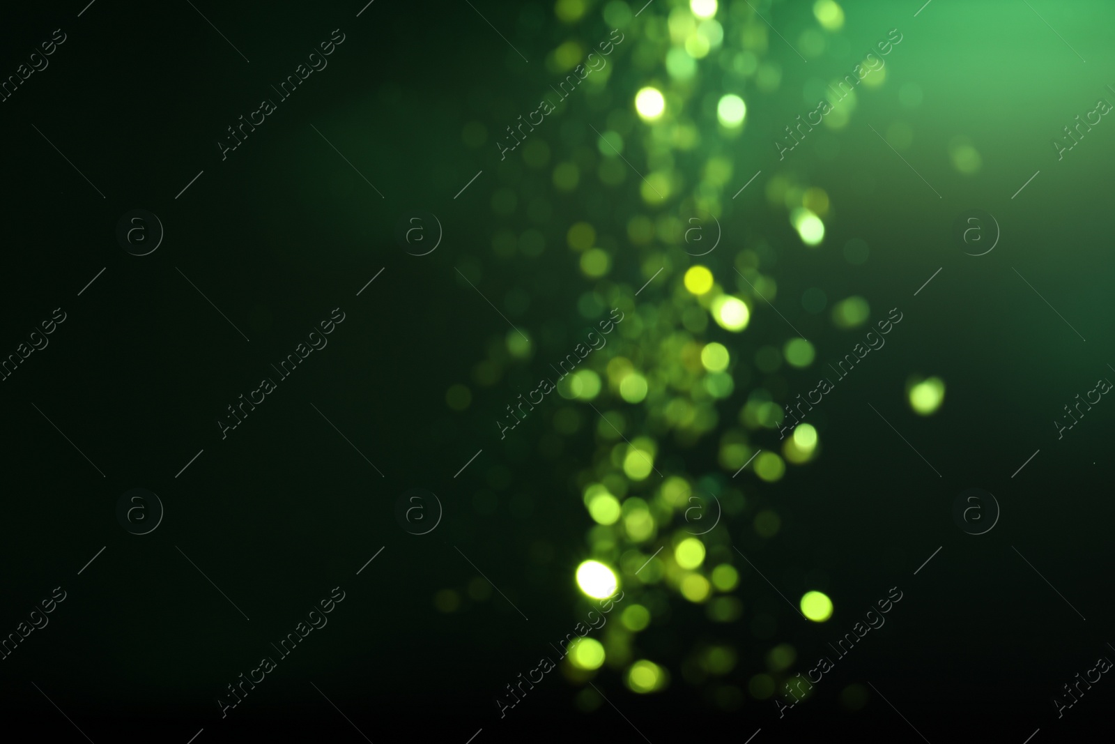 Photo of Blurred view of festive lights on green background. Bokeh effect