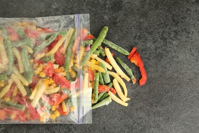 Photo of Zip bag with different frozen vegetables on grey table, top view. Space for text