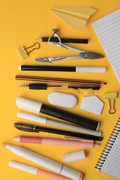 Photo of Flat lay composition with paper plane and different school stationery on orange background. Back to school