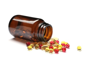 Photo of Bottle with different vitamin capsules on white background