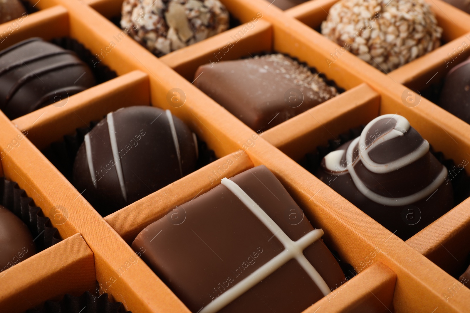 Photo of Box with different chocolate candies as background, closeup