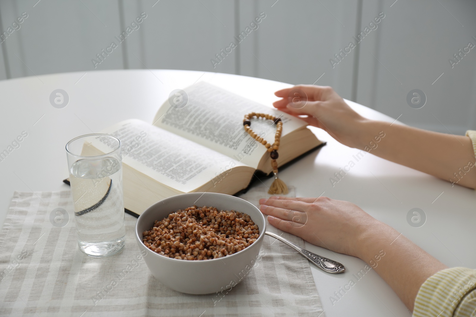 Photo of Woman with Bible having dinner at home, closeup. Great Lent season
