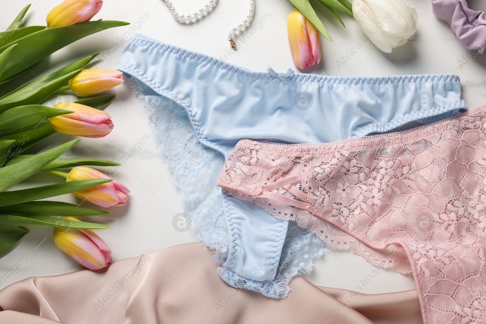 Photo of Elegant women's underwear and beautiful tulips on white background, flat lay