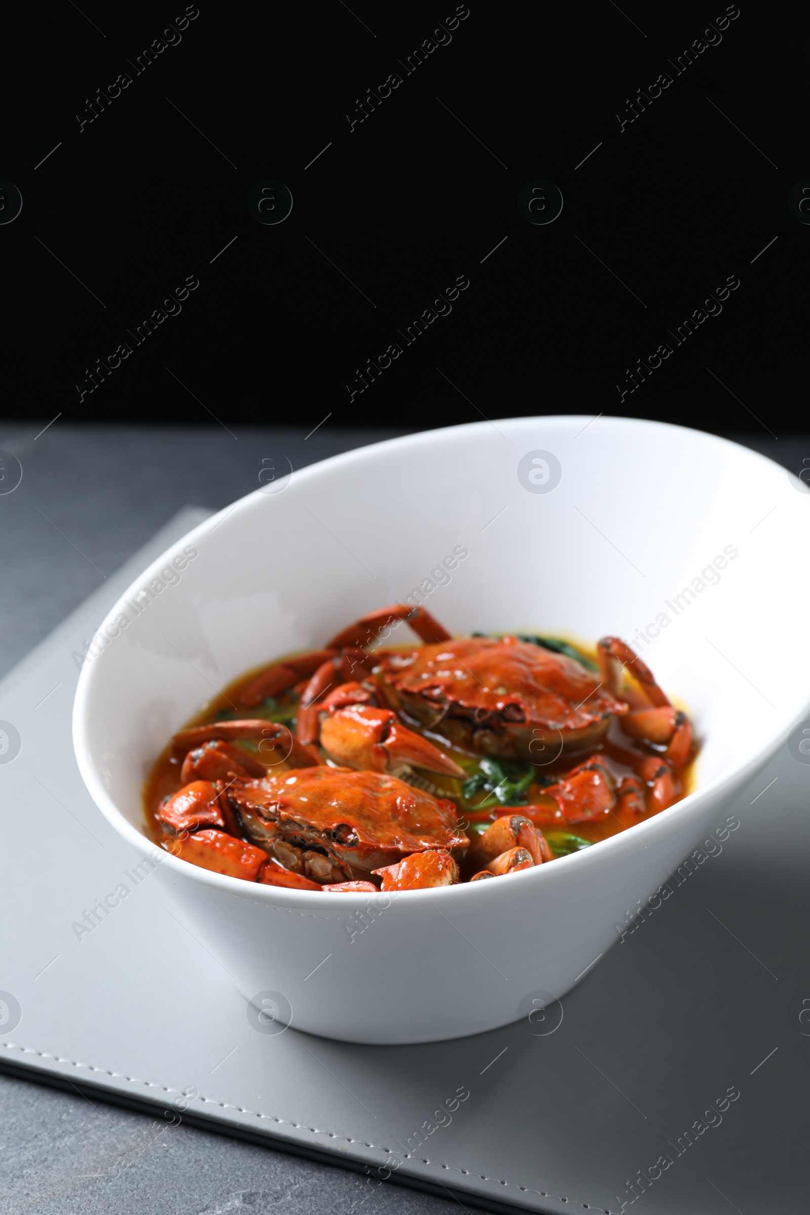 Photo of Delicious boiled crabs with sauce on table, space for text