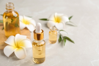 Photo of Beautiful spa composition with aroma oil and flowers on marble table. Space for text