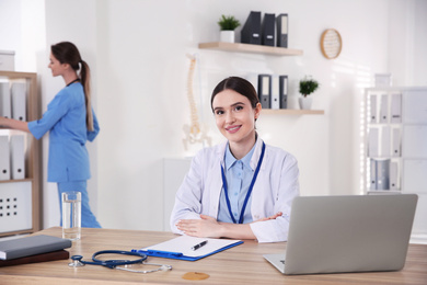 Photo of Portrait of female doctor at table in modern clinic