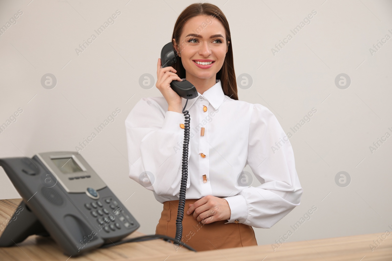 Photo of Female receptionist talking on phone at workplace