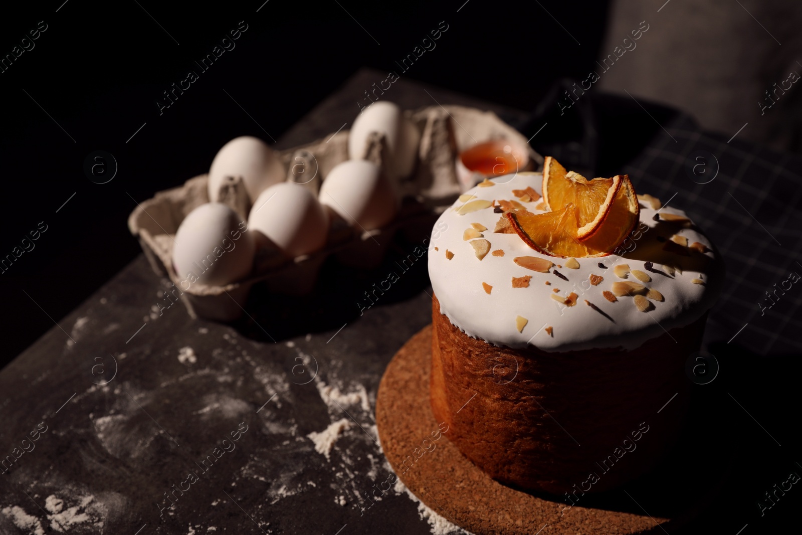 Photo of Traditional decorated Easter cake on black table. Space for text