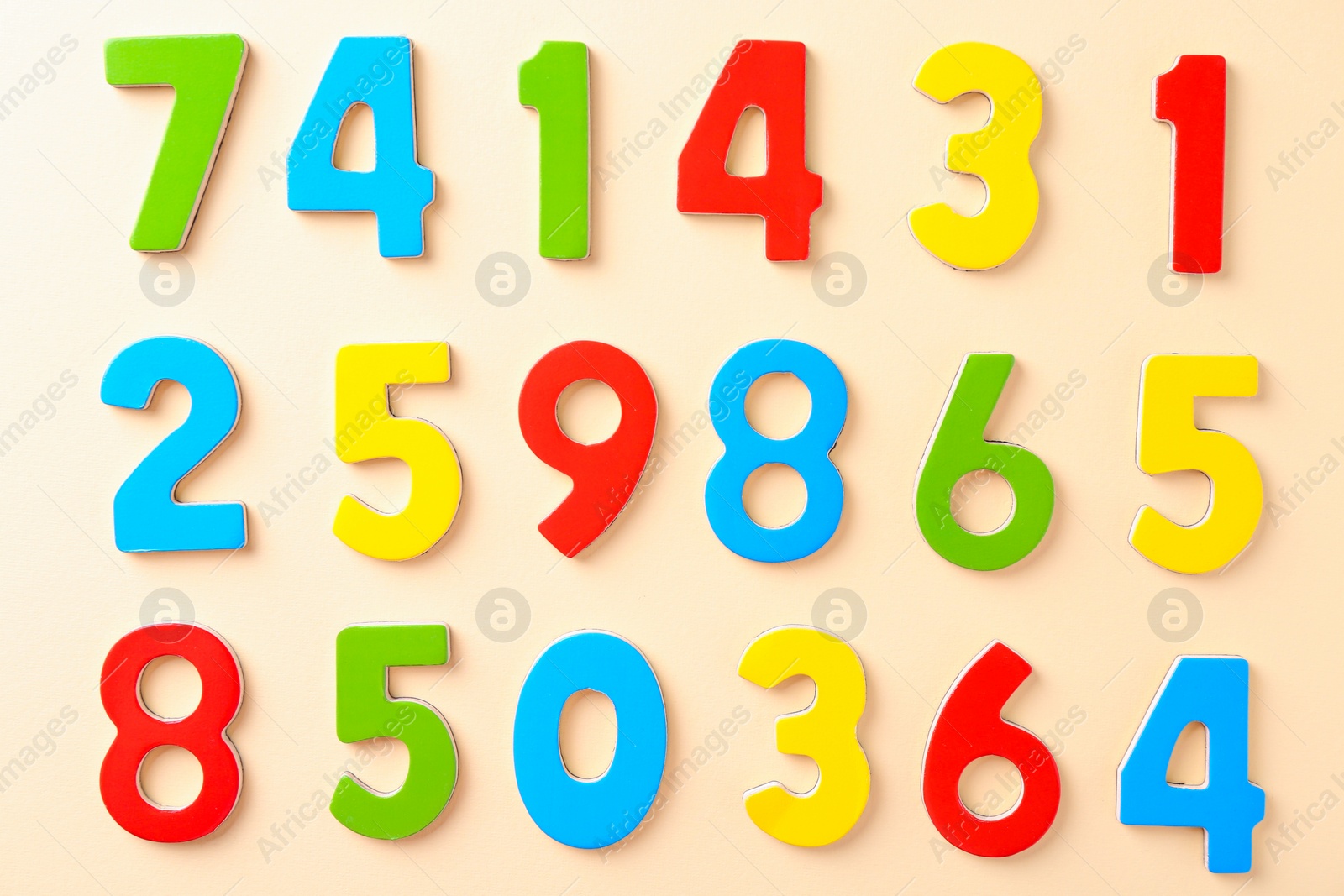 Photo of Colorful numbers on beige background, flat lay